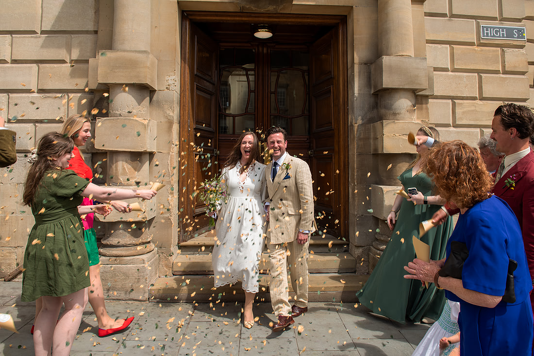 Couple on their wedding day in Bath. Confetti shot outside the registry office