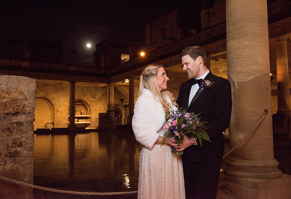 Sunset wedding at The Roman Baths. Couple looking at each other. Classic picture. Moon in the distance. Bath wedding photo. Historic venues in Bath.