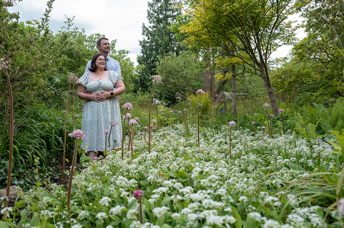 couple at their proposal at Botanical Gardens in Bath. Flowers are all around the couple