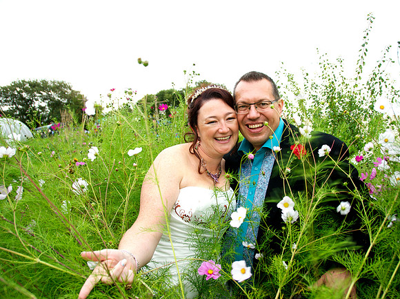 Bride and groom among wild flowers in garden
