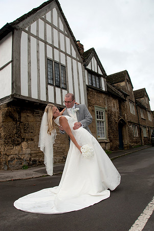 bride holding groom on street in Lacock